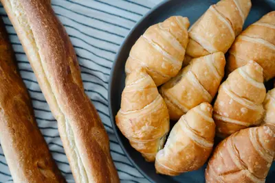 Fresh croissants and baguettes on a striped tablecloth